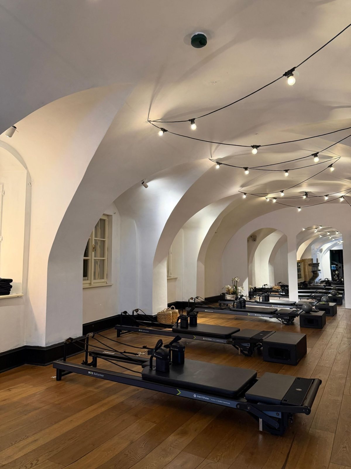 The RX Pilates studio in Prague, empty, with vaulted ceiling and reformers